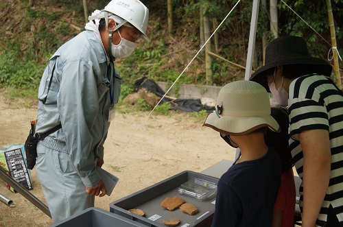 遺物の説明をする調査員